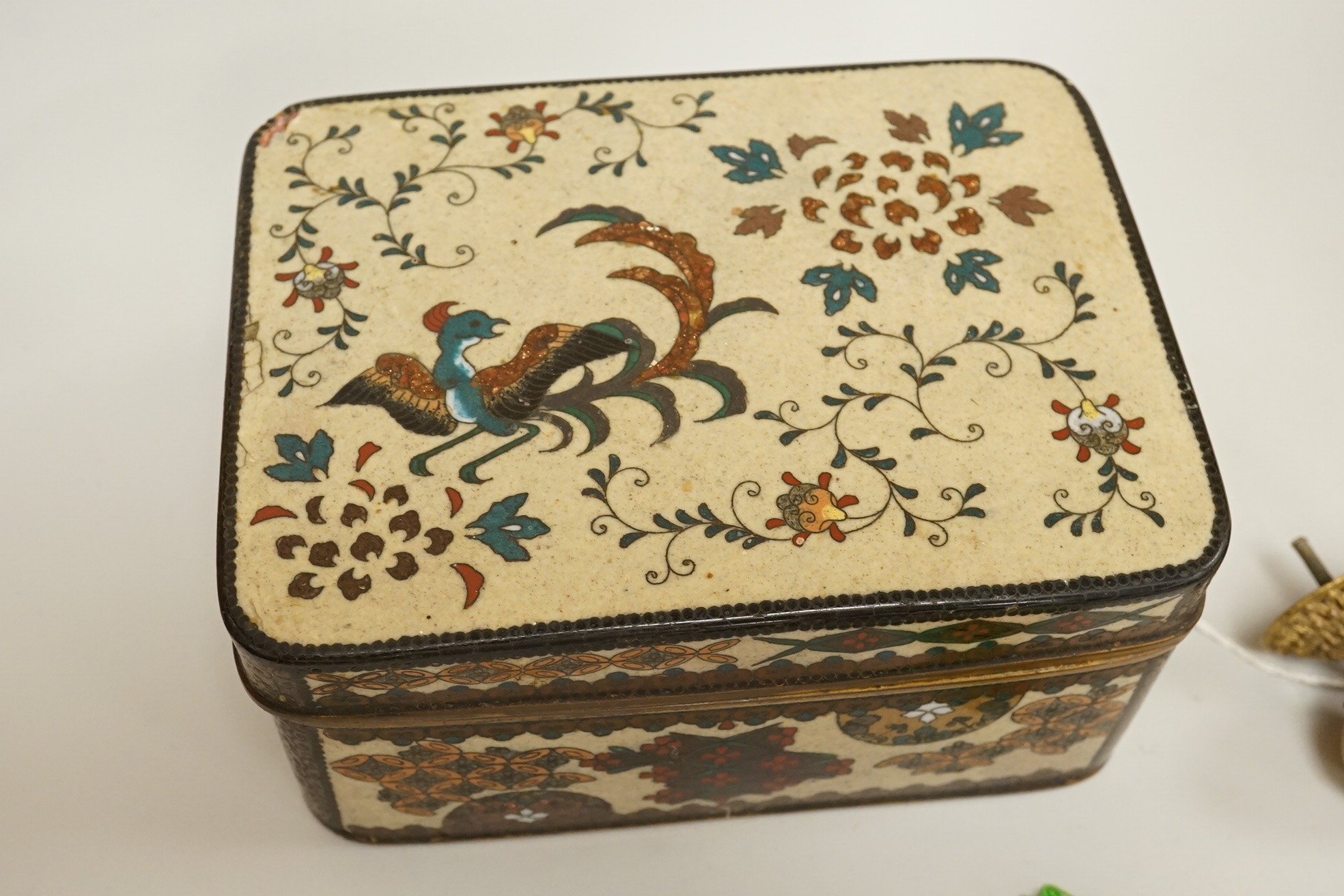 A large cloisonné enamel box containing a cast mask handle, an oval hair pendant, coins and medals, etc.